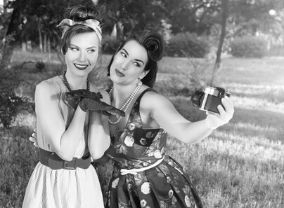 Zwei Frauen mit Vintage Kleid machen Foto